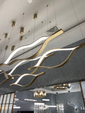 https://cdn.shopify.com/s/files/1/0736/8795/7790/files/modern-simple-brass-waving-chandelier-for-livingdining-roomkitchen-island-merlin-lamps-13.jpg?v=1765407448