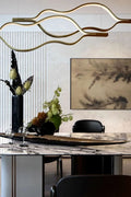 https://cdn.shopify.com/s/files/1/0736/8795/7790/files/modern-simple-brass-waving-chandelier-for-livingdining-roomkitchen-island-merlin-lamps-5.jpg?v=1765407433