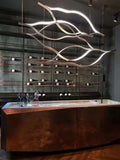 https://cdn.shopify.com/s/files/1/0736/8795/7790/files/modern-simple-brass-waving-chandelier-for-livingdining-roomkitchen-island-merlin-lamps-9.jpg?v=1765407440